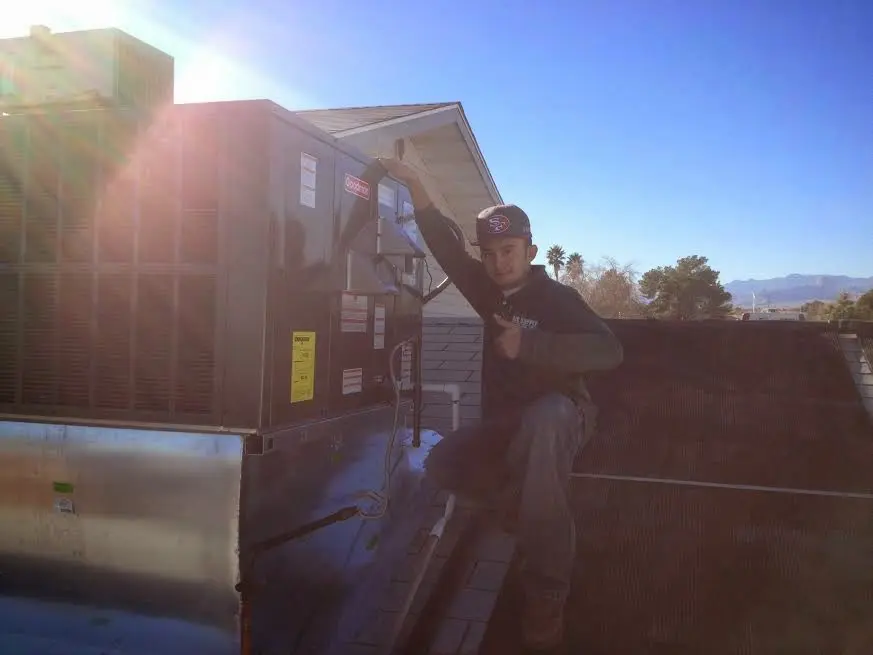 HVAC technician performing HVAC Inspection on a rooftop unit in Corinth
